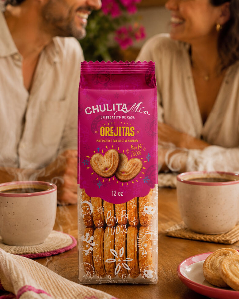 Paquete de orejitas Chulita Mía sobre una mesa, junto a tazas de café.